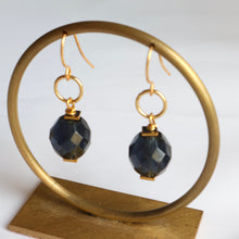 Load image into Gallery viewer, Gold earrings with dark blue beads on a gold stand against a white background