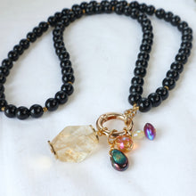Load image into Gallery viewer, Black beaded necklace with gold and multicolored charm on a white background