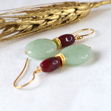Load image into Gallery viewer, Jewelry set with green and red beads on gold hooks, placed on a white fabric background.