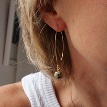 Load image into Gallery viewer, Close-up of a person wearing a gold earring with a small decorative element.
