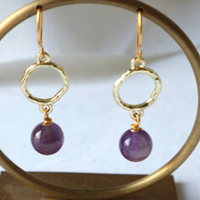Load image into Gallery viewer, Gold earrings with purple beads on a gold hoop stand.