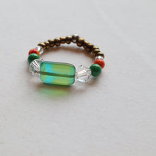 Load image into Gallery viewer, Ring with green glass bead and crystal on a light gray background