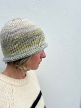Load image into Gallery viewer, Person wearing a knitted hat and white sweater against a light gray background