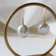 Load image into Gallery viewer, Pearl earrings hanging on a gold hoop against a neutral background