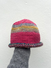 Load image into Gallery viewer, Knitted multicolored hat on a gray sock against a white background