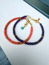 Load image into Gallery viewer, Two beaded bracelets with coral orange and deep purple beads, accented with gold spacer beads and clasp hardware, displayed on a light gray surface.