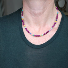 Load image into Gallery viewer, Person wearing a colorful beaded necklace against a dark shirt background