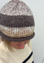 Load image into Gallery viewer, Person wearing a striped knit beanie with a plain background