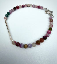Load image into Gallery viewer, A beaded bracelet featuring faceted gemstone beads in shades of pink, purple, green, and brown, accented by a silver-toned bar clasp and chain closure, displayed on a light textured background.