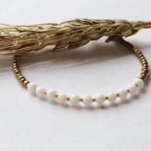 Load image into Gallery viewer, Bracelet with white beads and gold accents on a light background