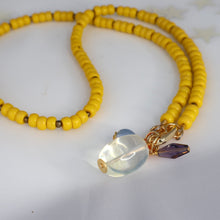 Load image into Gallery viewer, Yellow beaded necklace with a clear and purple pendant on a white background