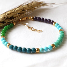 Load image into Gallery viewer, Multicolored beaded bracelet with gold accents on a white background