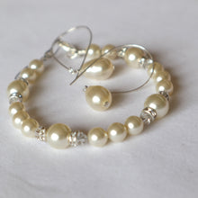 Load image into Gallery viewer, Pearl bracelet and earrings set on a light gray background