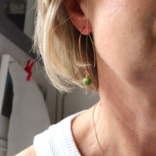 Load image into Gallery viewer, Close-up of a person wearing a green bead earring with a blurred background
